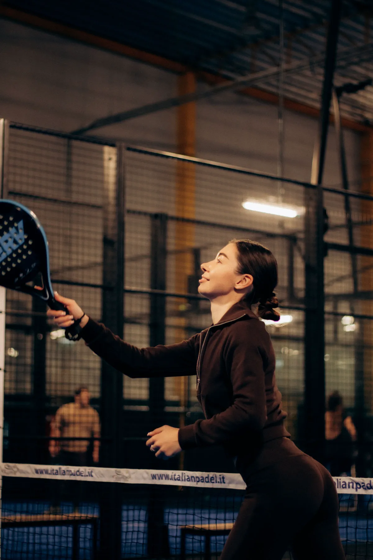 A padel player focused on a shot during training